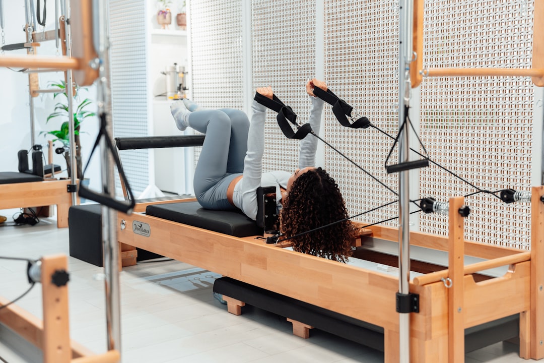 a woman is doing exercises on a rowing machine — Foto: Ahmet Kurt/Unsplash